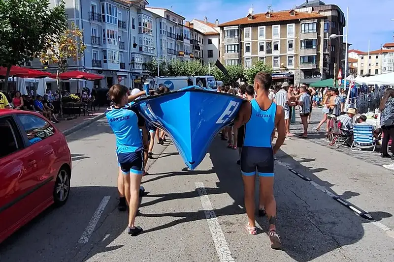 Los remeros de Lutxana Arraun Elkartea transportan la trainera Ederra antes de comenzar la regata por la LII Bandera Ciudad de Castro-Urdiales