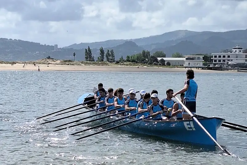 Los remeros de Lutxana Arraun Elkartea, participando en la regata de traineras LIV Bandera Excelentísimo Ayuntamiento de Santoña, con la playa de El Puntal de Laredo al Fondo